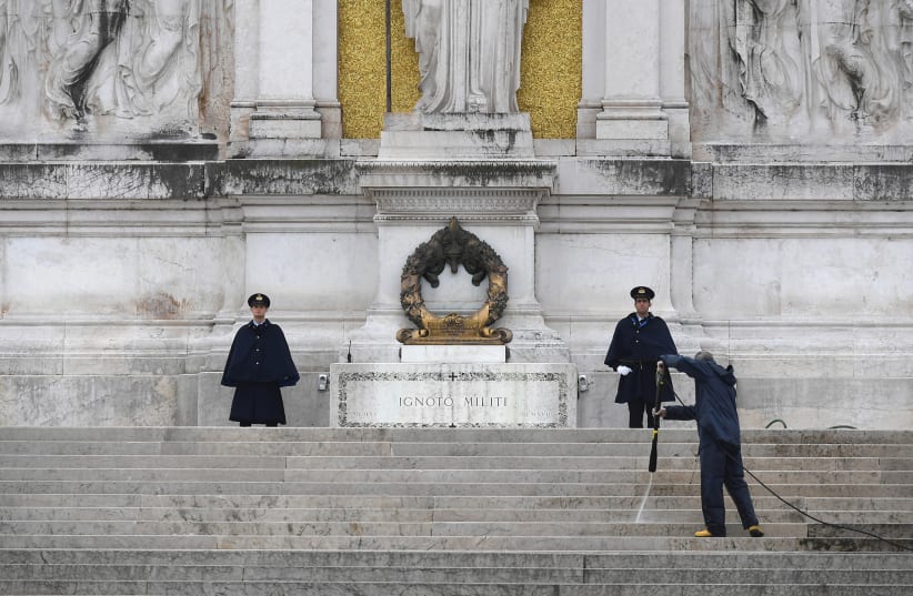 A MAN disinfects stairs leading to the monument in honor of unknown soldiers at Piazza Venezia as Italy tightened measures to try and contain the spread of coronavirus, in Rome on Saturday. (photo credit: REUTERS)
