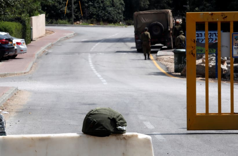 A sign in Hebrew is stuck onto a barricade and reads, "Blocked route, no entry for military vehicles of any sort" near a gate in Zar'it northern Israel, August 28, 2019. (photo credit: AMMAR AWAD/REUTERS)