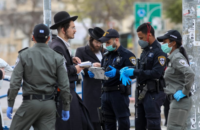 Police officers close synagogues and disperse public gatherings in an ultra orthodox Jewish neighborhood in Beit Shemesh, following the government's decisions, in an effort to contain the spread of the coronavirus on March 31, 2020 (photo credit: YAAKOV LEDERMAN)