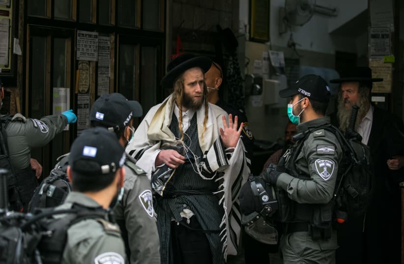 Police officers close synagogues and disperse public gatherings in the ultra orthodox Jewish neighborhood of Meah Shearim, following the government's decisions, in an effort to contain the spread of the coronavirus. March 31, 2020. Photo by Olivier Fitoussi/Flash90 (photo credit: OLIVIER FITOUSSI/FLASH90)