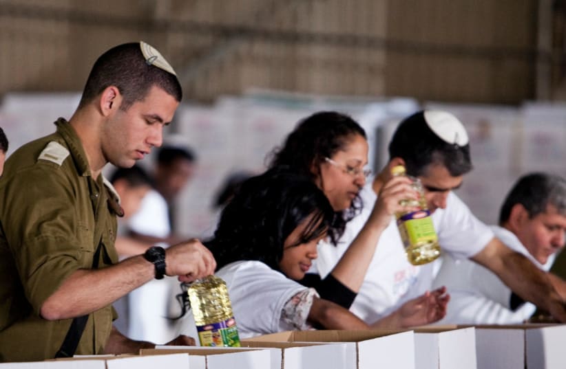 Israelis placing food in charity boxes  (photo credit: Courtesy)
