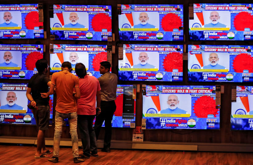 People watch Indian Prime Minister Narendra Modi addressing the nation amid concerns about the spread of corona, in Ahmedabad, India on March 19 (photo credit: AMIT DAVE)
