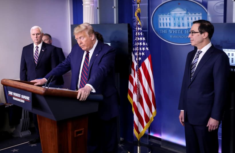 US President Donald Trump addresses the daily coronavirus response briefing as Vice President Mike Pence and Treasury Secretary Steven Mnuchin listen at the White House in Washington, US, April 2, 2020 (photo credit: REUTERS)