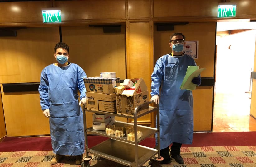 Members of the hotel staff wear protective gear while serving food at the Dan Panorama Hotel in Tel Aviv. (photo credit: AMIT KATZAV)
