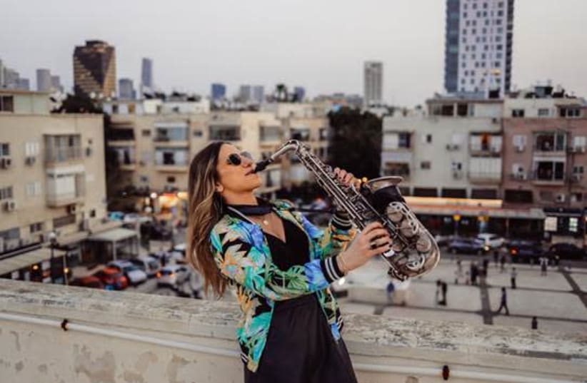 YARDEN KLAYMAN blows the sax during her rooftop solo gig in Tel Aviv’s Basel neighborhood last week.  (photo credit: IDAN HERSHKO & TEL AVIV MUNICIPALITY)
