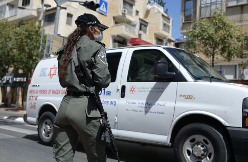 An IDF soldier stands infront of a Magen David Adom ambulance at a checkpoint at the entrance to Bnei Brak (photo credit: FLASH90)