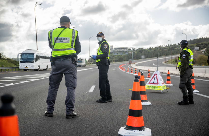Police at a temporary "checkpoint" on road number 1 outside Jerusalem on April 8, 2020, to check if people are not disobeying the governments orders on a lockdown, in order to prevent the spread of the Coronavirus. (photo credit: YONATAN SINDEL/FLASH90)