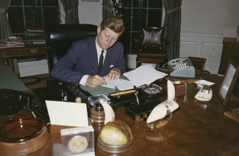 President John F. Kennedy signs a proclamation for the interdiction of the delivery of offensive weapons to Cuba during the Cuban missile crisis, at the White House in Washington in this handout photograph taken on October 23, 1962 (photo credit: REUTERS/CECIL STOUGHTON/THE WHITE HOUSE/JOHN F. KENNEDY PRESIDENTIAL LIBRARY)