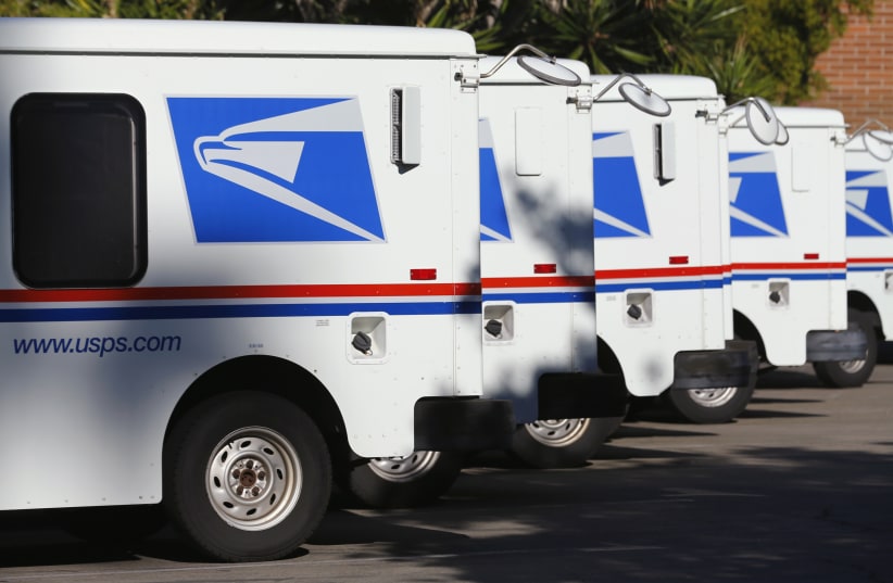 U.S. postal service trucks sit parked at the post office in Del Mar, California (photo credit: REUTERS)