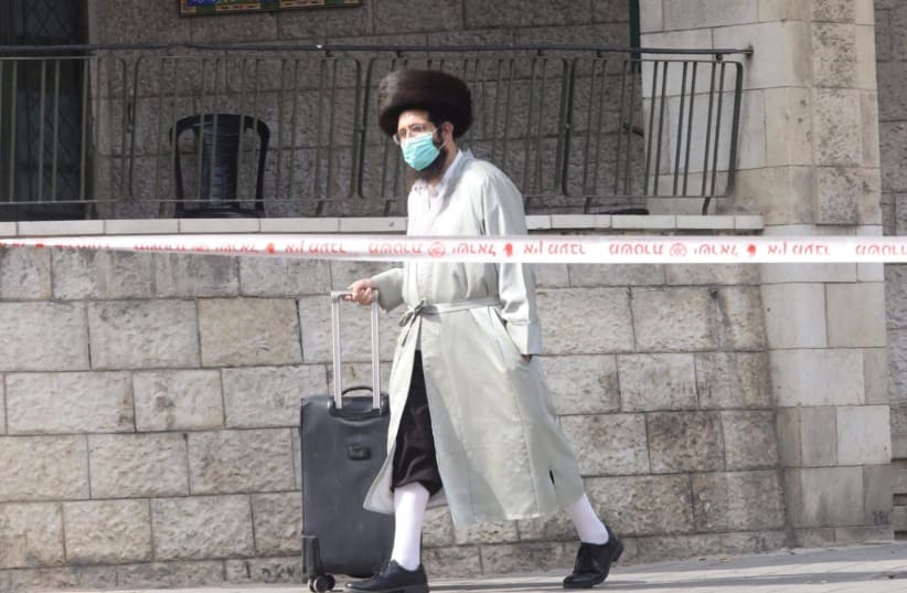 A Haredi man walking with a mask in the neighborhood of Meaa Shearim   (photo credit: MARC ISRAEL SELLEM)