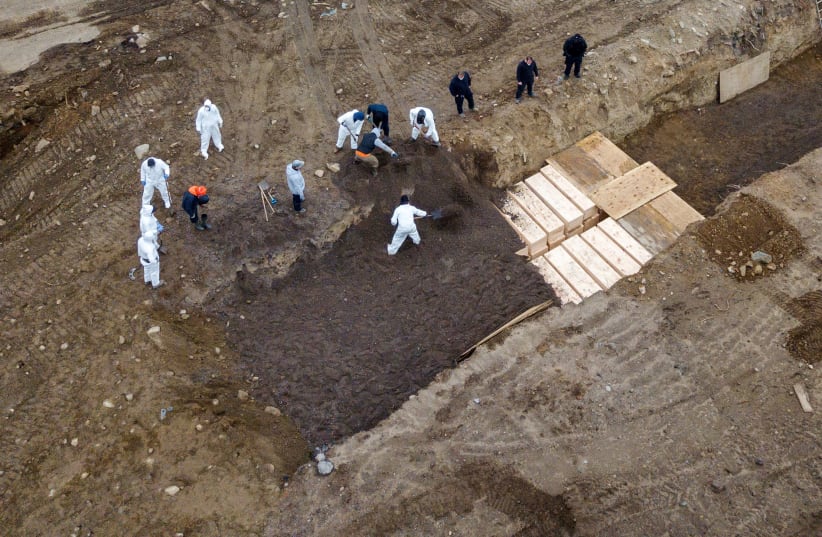 Drone pictures show bodies being buried on New York's Hart Island where the department of corrections is dealing with more burials overall, amid the coronavirus disease (COVID-19) outbreak in New York City, U.S., April 9, 2020. (photo credit: LUCAS JACKSON / REUTERS)