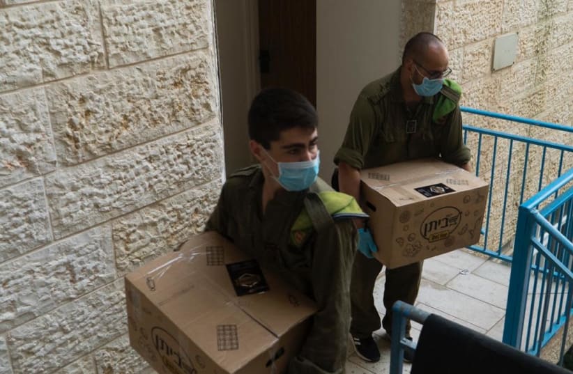 IDF soldiers in Beitar Illit delivering food packages to those in need.  (photo credit: IDF SPOKESMAN’S UNIT)