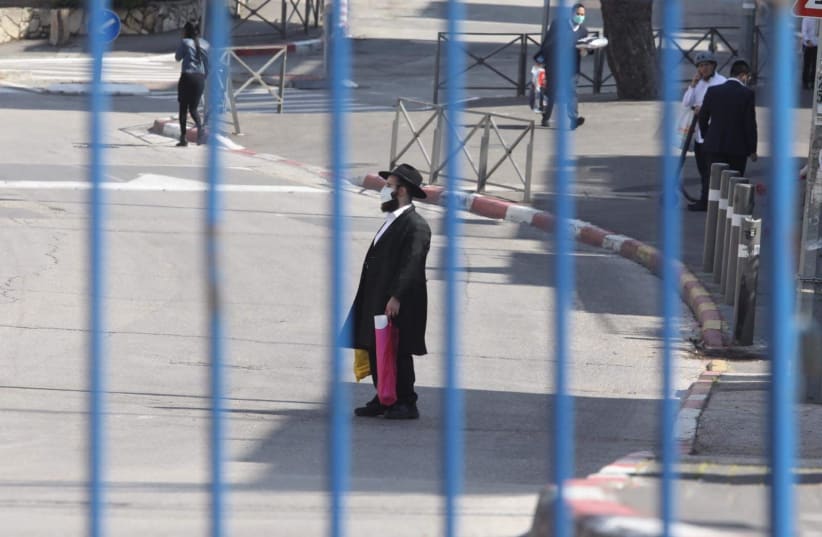 A man is seen behind a fence at Jerusalem's Bayit Vagan neighboorhood (photo credit: MARC ISRAEL SELLEM/THE JERUSALEM POST)