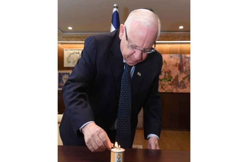 President Reuven Rivlin lighting a memorial candle from Our 6 Million (photo credit: MARC NEYMAN/GPO)