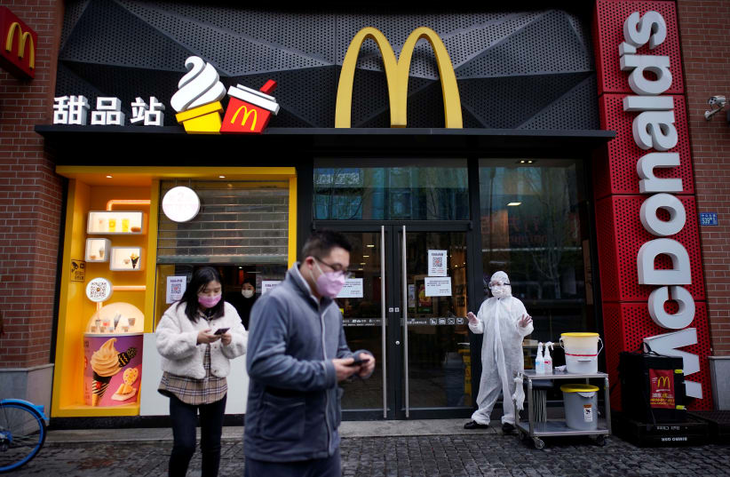 People wearing face masks are seen outside a McDonald's restaurant in Wuhan (photo credit: REUTERS)