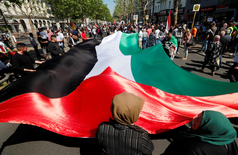 Protesters hold a large Palestinian flag during a demonstration marking al-Quds Day (Jerusalem Day), in Berlin, Germany June 1, 2019 (photo credit: REUTERS/FABRIZIO BENSCH)