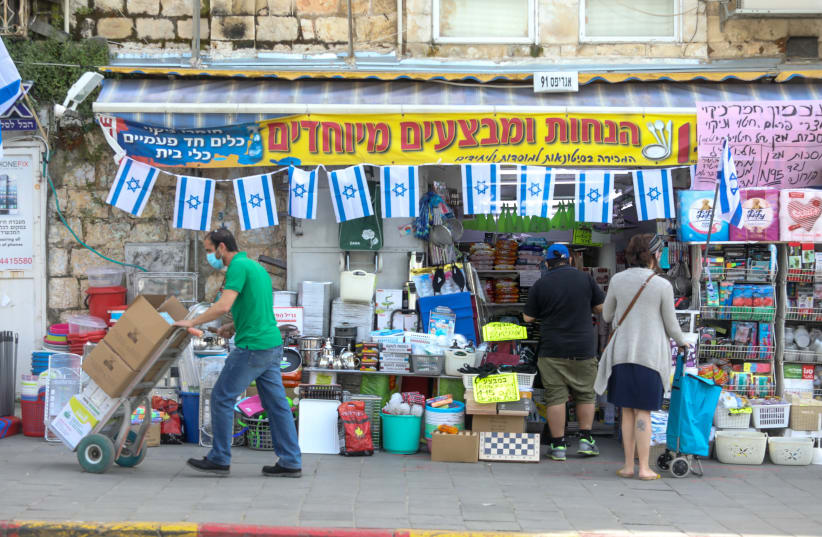 A shop opens at Agripas street in Jerusalem next to the Machane Yehuda market (photo credit: MARC ISRAEL SELLEM/THE JERUSALEM POST)