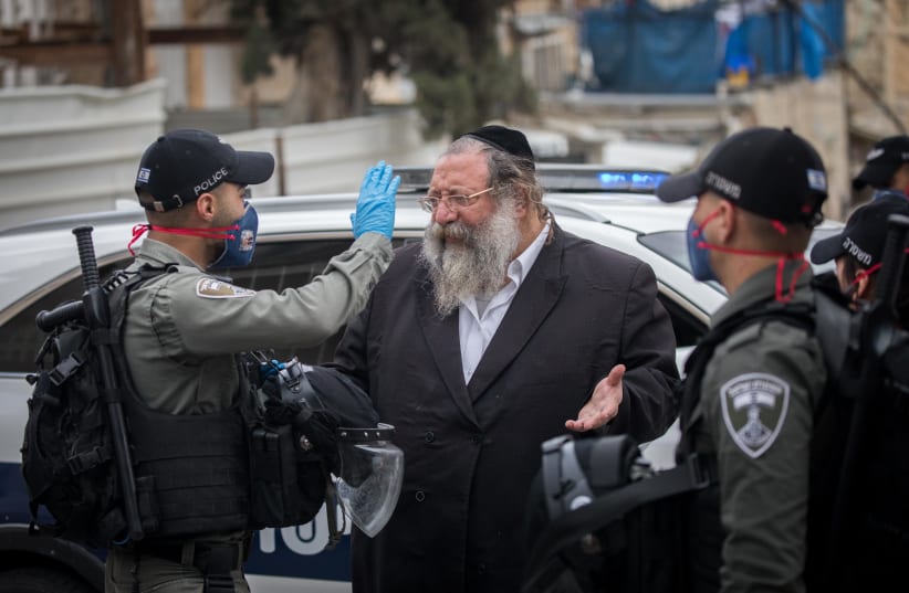 Police officers close synagogues and handing out fines to ultra orthodox Jews at the Bukharim quarter in Jerusalem, following the government's decisions, in an effort to contain the spread of the coronavirus, April 17, 2020 (photo credit: YONATAN SINDEL/FLASH 90)