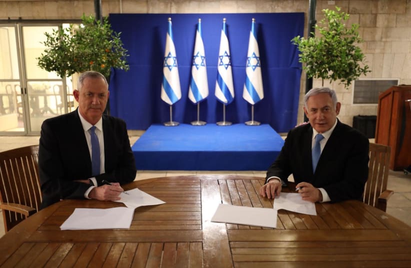 Prime Minister Benjamin Netanyahu and Blue and White leader Benny Gantz sign a unity government agreement (photo credit: Courtesy)