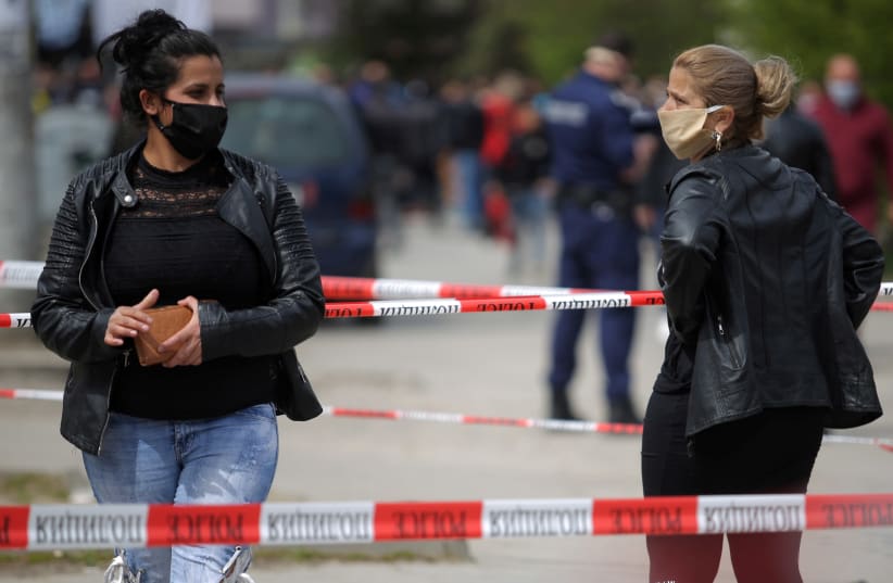 Women are pictured near police lines at the biggest Roma-populated district in Sofia, Bulgaria, April 17, 2020. (photo credit: REUTERS/DIMITAR KYOSEMARLIEV)