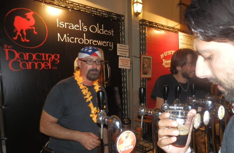 DAVID COHEN, owner of the Dancing Camel Brewery in Tel Aviv, greets visitors at a local beer festival.  (photo credit: Courtesy)