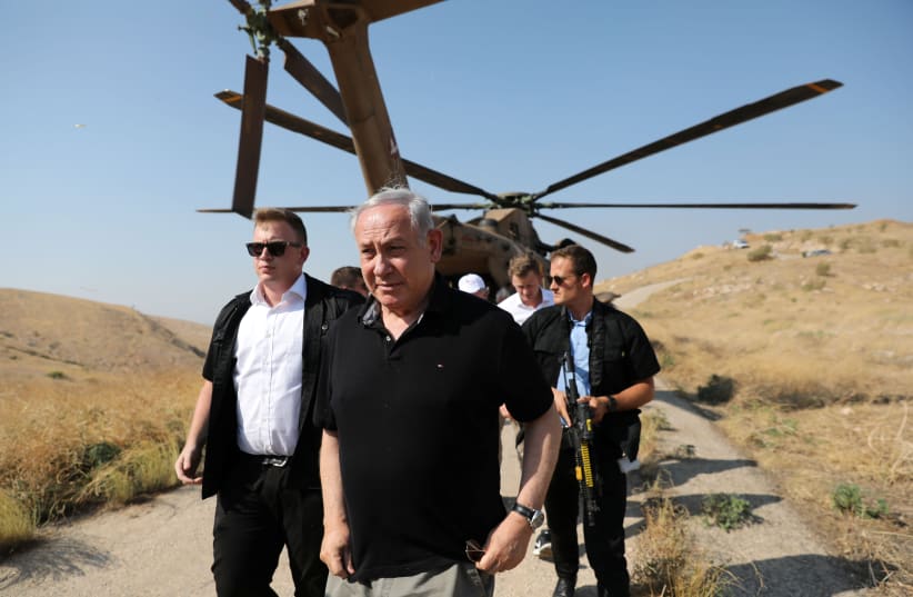 PRIME MINISTER Benjamin Netanyahu walks out of a military helicopter, as he visits an old army outpost overlooking the Jordan Valley last year. (photo credit: ABIR SULTAN / REUTERS)