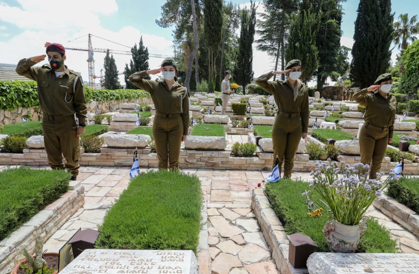 Soldiers saluting graves ahead of Israel Memorial Day at Mount Hertzl (photo credit: MARC ISRAEL SELLEM/THE JERUSALEM POST)