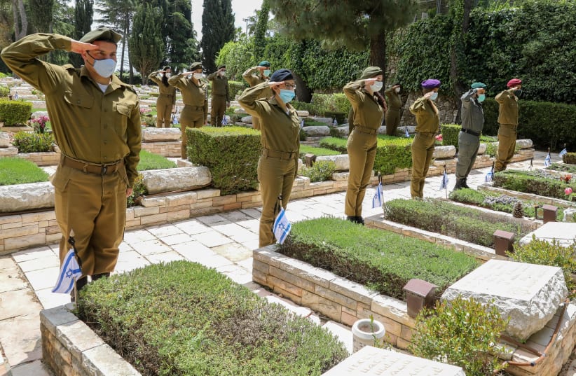 Soldiers saluting graves ahead of Israel's Memorial Day at Mount Hertzl (photo credit: MARC ISRAEL SELLEM/THE JERUSALEM POST)