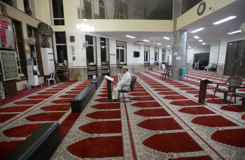 A Jordanian Imam reads the Koran in an empty mosque during Ramadan as prayers by worshipers are suspended due to concerns about the spread of the coronavirus. Amman, Jordan, April 26, 2020. (photo credit: MOHAMMAD HAMED / REUTERS)