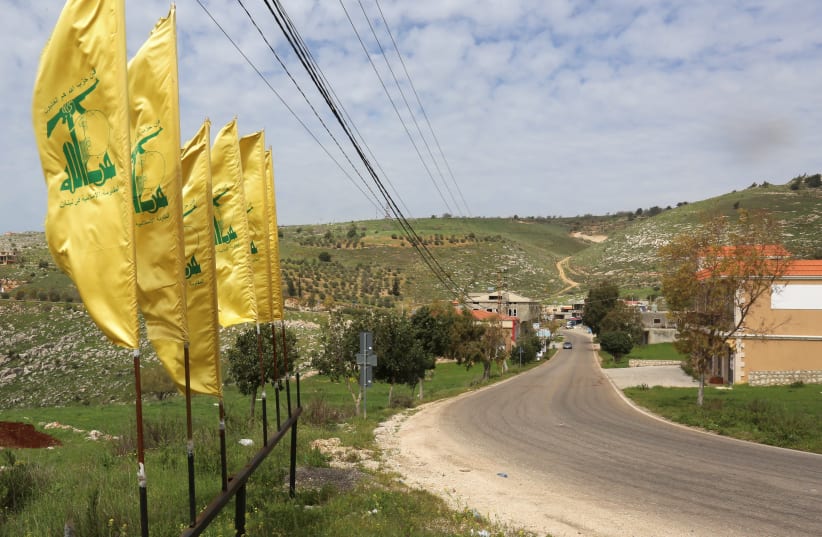 HEZBOLLAH FLAGS flutter along an empty street, at the entrance of Mays Al-Jabal village (photo credit: SETH J. FRANTZMAN)