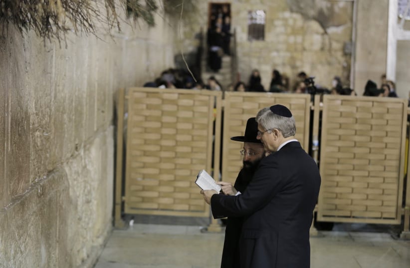 Then-Canadian prime minister Stephen Harper (right) looks at a Bible with Western Wall Rabbi Shmuel Rabinowitz, 2014 (photo credit: AMMAR AWAD/REUTERS)