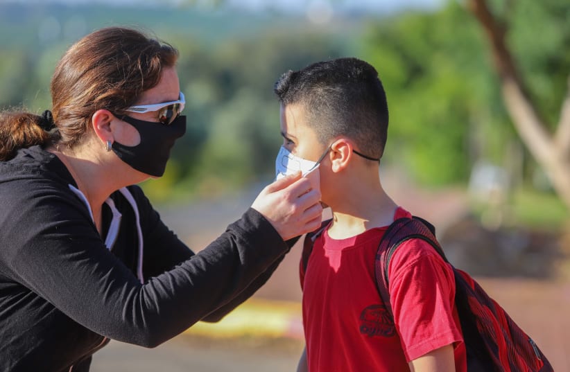 Israeli children wearing face masks make their way to school in Moshav Yashresh, on May 3, 2020 (photo credit: YOSSI ALONI/FLASH90)