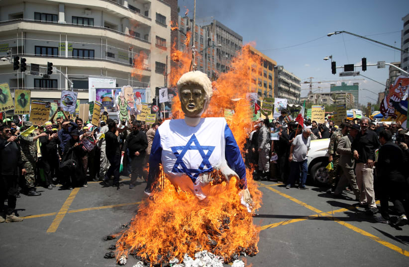 Iranians burn an effigy in the likeness of U.S. President Donald Trump during a protest marking the annual al-Quds Day (Jerusalem Day) on the last Friday of the holy month of Ramadan in Tehran, Iran June 8, 2018 (photo credit: TASNIM NEWS AGENCY)