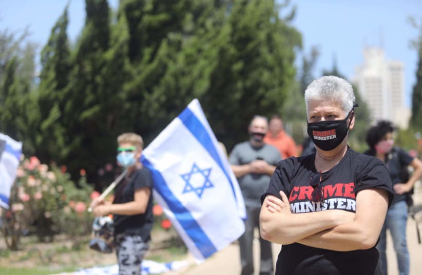 Protesters outside the Knesset watch the High Court's session of whether Prime Minister Benjamin Netanyahu can form a government, May 3, 2020 (photo credit: MARC ISRAEL SELLEM/THE JERUSALEM POST)