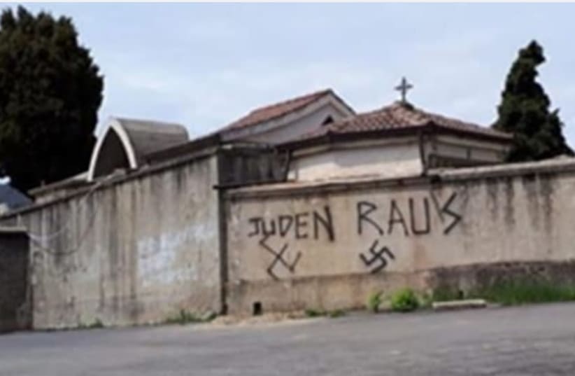 Antisemitic graffiti is seen outside a cemetary in Soveria Mannelli, Italy. (photo credit: LACNEWS24)