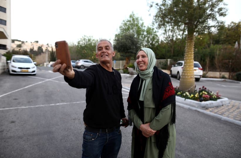 Joint List MK Iman Yassin Khatib, the first lawmaker in Israel’s history to wear a hijab, takes a selfie with a friend in Nazareth on March 5 (photo credit: REUTERS/AMMAR AWAD)