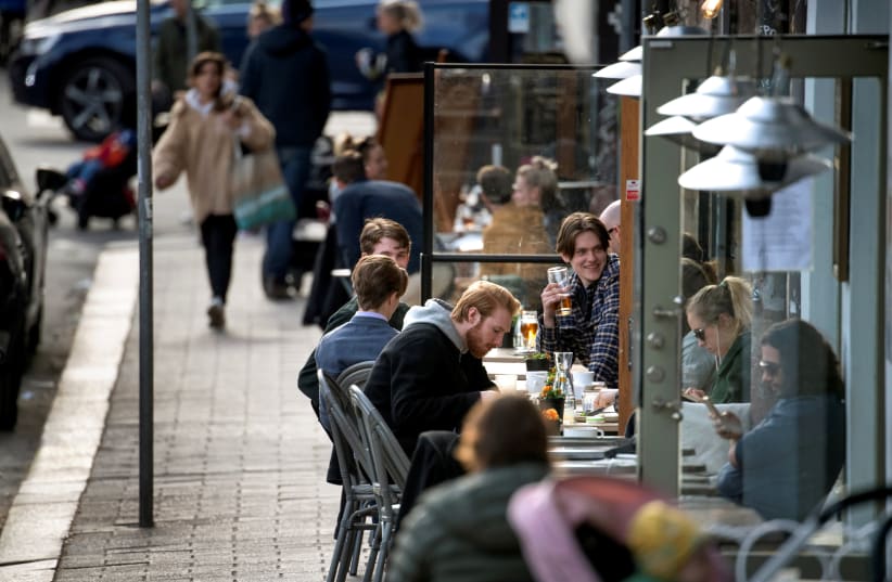 SWEDES ENJOY themselves at an outdoor restaurant amid the coronavirus outbreak, in Stockholm on April 20 (photo credit: REUTERS)