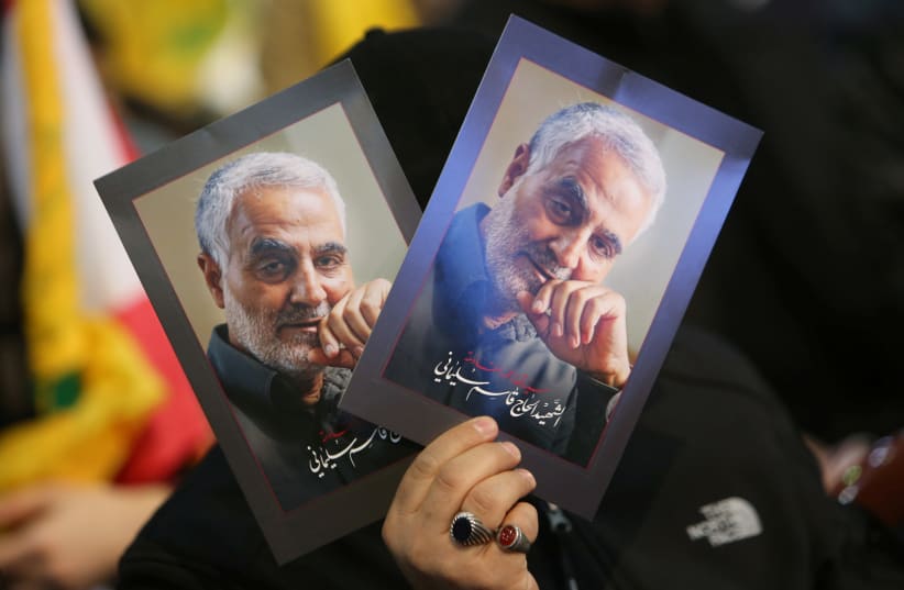 A supporter of Lebanon's Hezbollah leader Sayyed Hassan Nasrallah carries pictures of the late Iran's Quds Force top commander Qassem Soleimani during a rally commemorating the annual Hezbollah's slain leaders in Beirut's southern suburbs, Lebanon February 16, 2020 (photo credit: REUTERS/AZIZ TAHER)