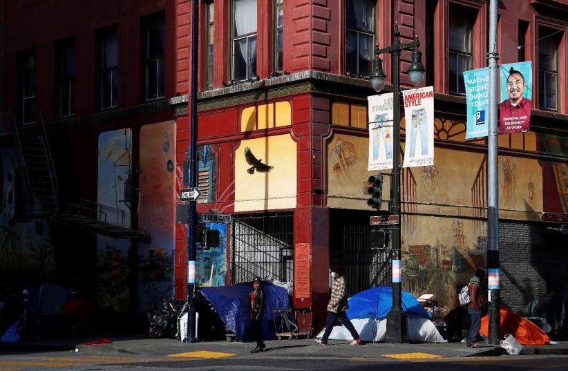 Tents set up by homeless people are seen on a corner street as people walk by amid an outbreak of the coronavirus disease (COVID-19), in the Tenderloin district of San Francisco, California, U.S. March 27, 2020 (photo credit: REUTERS)