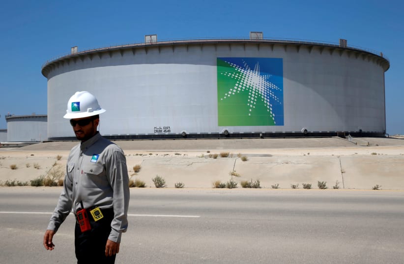 AN ARAMCO employee passes an oil tank at Saudi Aramco’s Ras Tanura oil refinery and terminal in 2018. (photo credit: AHMED JADALLAH/REUTERS)