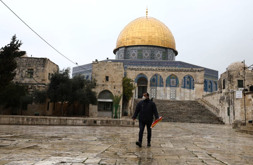 A man walks in front of the Dome of the Rock, March 20, 2020 (photo credit: AMMAR AWAD/REUTERS)