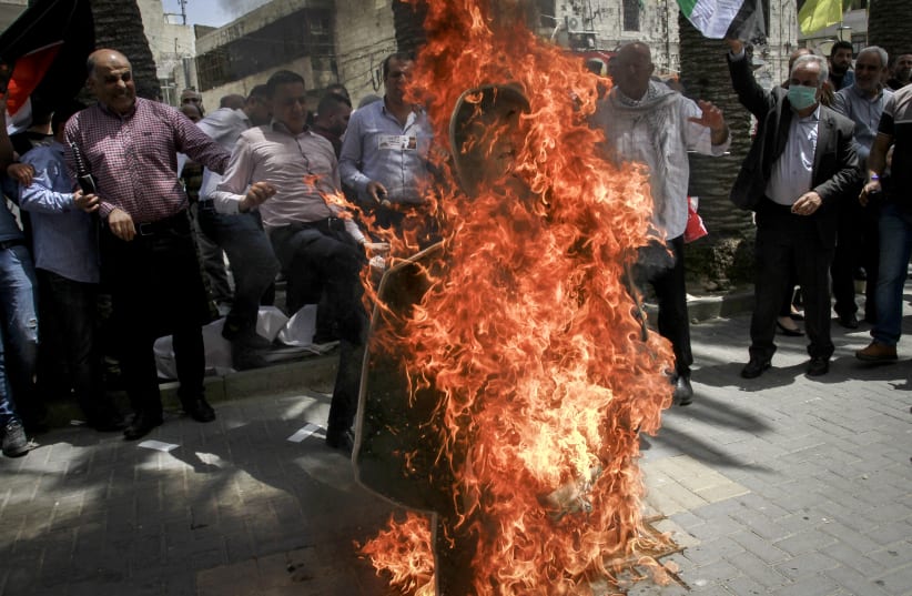 Palestinian protestors burn a Photo of US Secretary of State Mike Pompeo, during a protest against U.S. President Donald Trump's Middle East peace plan, in the West Bank city of Nablus, May 14, 2020. (photo credit: NASSER ISHTAYEH/FLASH90)