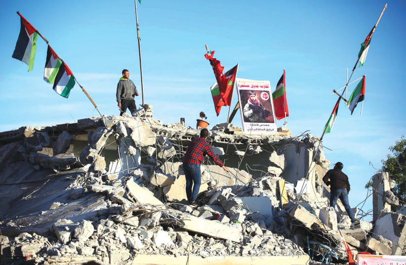 AFTER THE IDF demolished it, Palestinians stand on the remains of the house of Qassam Al-Barghouti who was involved in the murder of 17-year-old Rina Shnerb, last year. (photo credit: FLASH90)