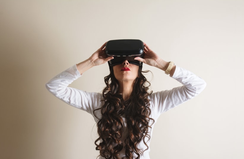 Woman with virtual reality goggles (illustrative) (photo credit: INGIMAGE)