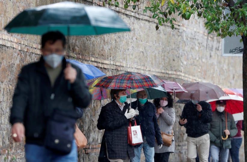 ILE PHOTO: People queue to receive free protective masks that have been bought by evangelicals in China and are distributed by Members of the Evangelical Christian Church, as the spread of the coronavirus disease (COVID-19) continues, in Rome, April 22, 2020 (photo credit: REUTERS/YARA NARDII/FILE PHOTO)