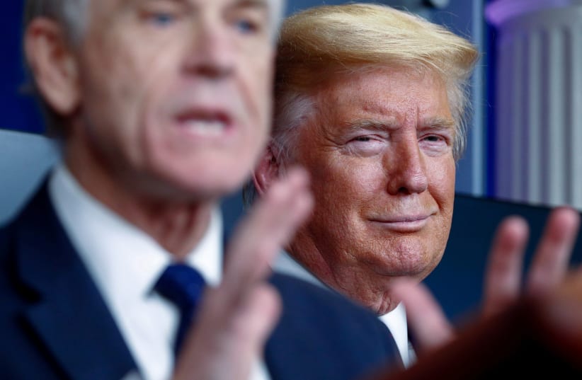U.S. President Donald Trump listens as White House Director of Trade and Marketing Policy Peter Navarro addresses the daily coronavirus response briefing at the White House in Washington, U.S., April 2, 2020.  (photo credit: REUTERS/TOM BRENNER)
