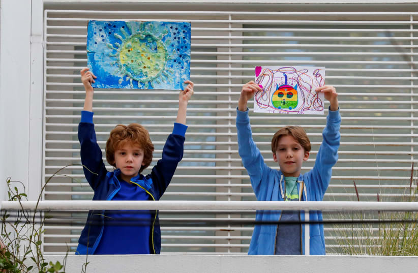 Children's drawings from lockdown show the world what they miss most. Juan, 8, and Mateo, 10, at their home in Buenos Aires, Argentina, April 14, 2020 (photo credit: REUTERS/AGUSTIN MARCARIAN)