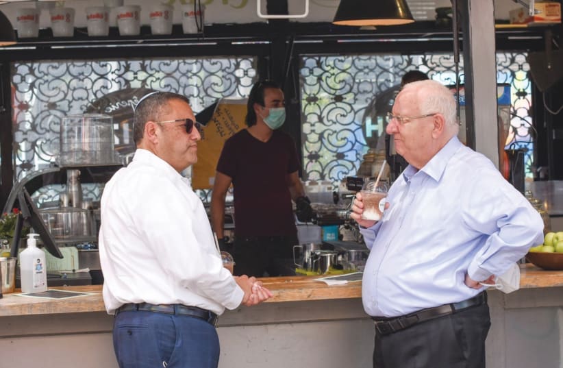 PRESIDENT REUVEN RIVLIN enjoys a takeaway iced coffee while visiting the Jerusalem Business Center with Jerusalem Mayor Moshe Lion. (photo credit: NOAM MORANO)