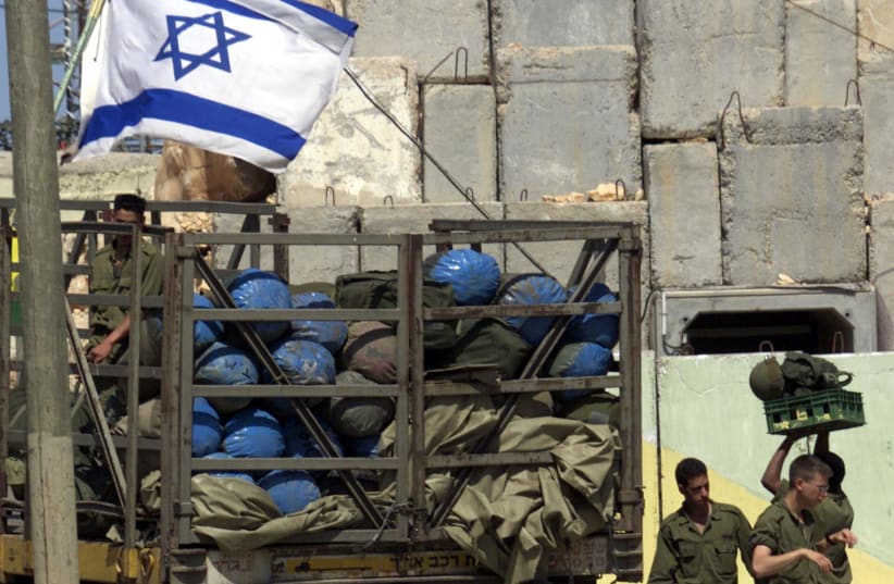 IDF SOLDIERS pack their bags as troops prepare to leave the Lebanon border, on May 17, 2000 (photo credit: HL/WS/REUTERS)