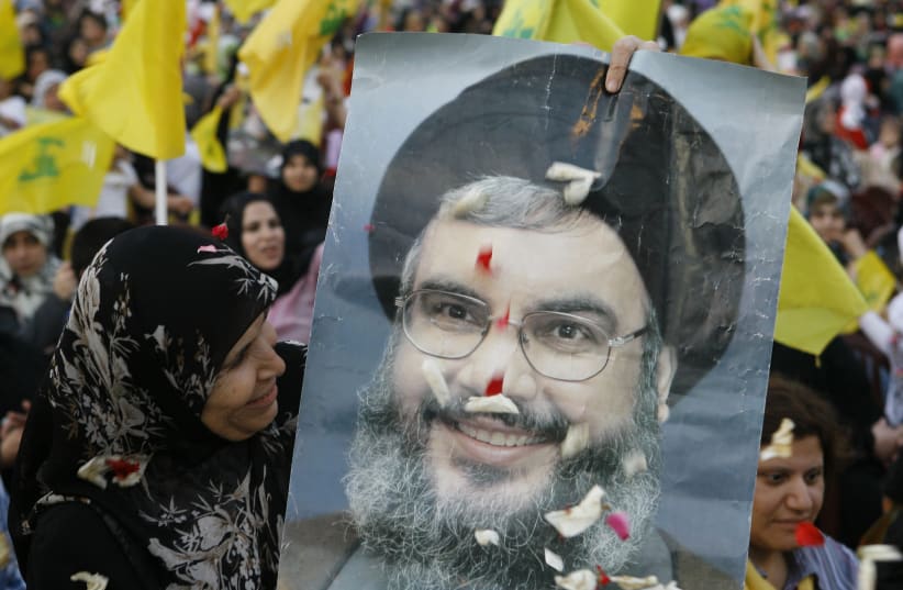 A HEZBOLLAH supporter beams at a poster of Hezbollah leader Hassan Nasrallah during a rally on the anniversary of the Israeli withdrawal, on May 25, 2009 (photo credit: JAMAL SAIDI/ REUTERS)